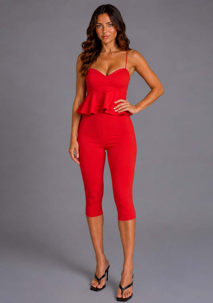 Front image of a model wearing the VSPR Capri Cropped Red Pants featuring a high-rise waist, clean lines, vibrant red hue and elegant cropped profile, standing against a grey studio backdrop