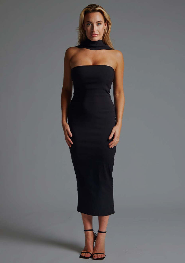 Front image of blonde model wearing a black collar detail midaxi dress with a straight neckline and collar detailing at the neck with straps at the back and statement gold centre back zip. The design featured Vesper Dion Collar Detail Midaxi Dress in Black