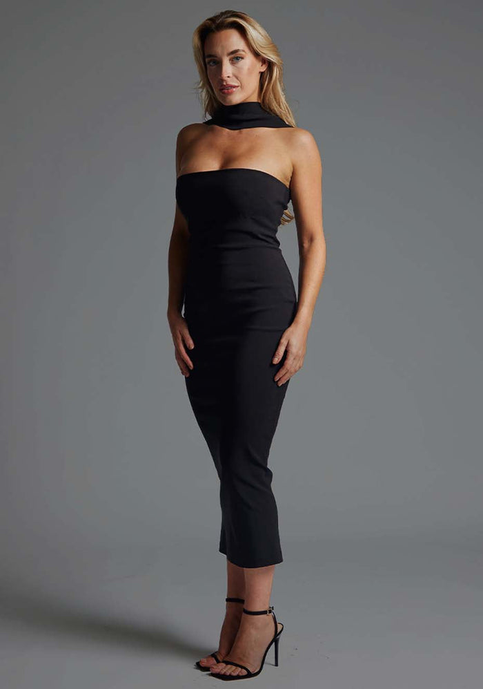 Side front image of blonde model wearing a black collar detail midaxi dress with a straight neckline and collar detailing at the neck with straps at the back and statement gold centre back zip. The design featured Vesper Dion Collar Detail Midaxi Dress in Black