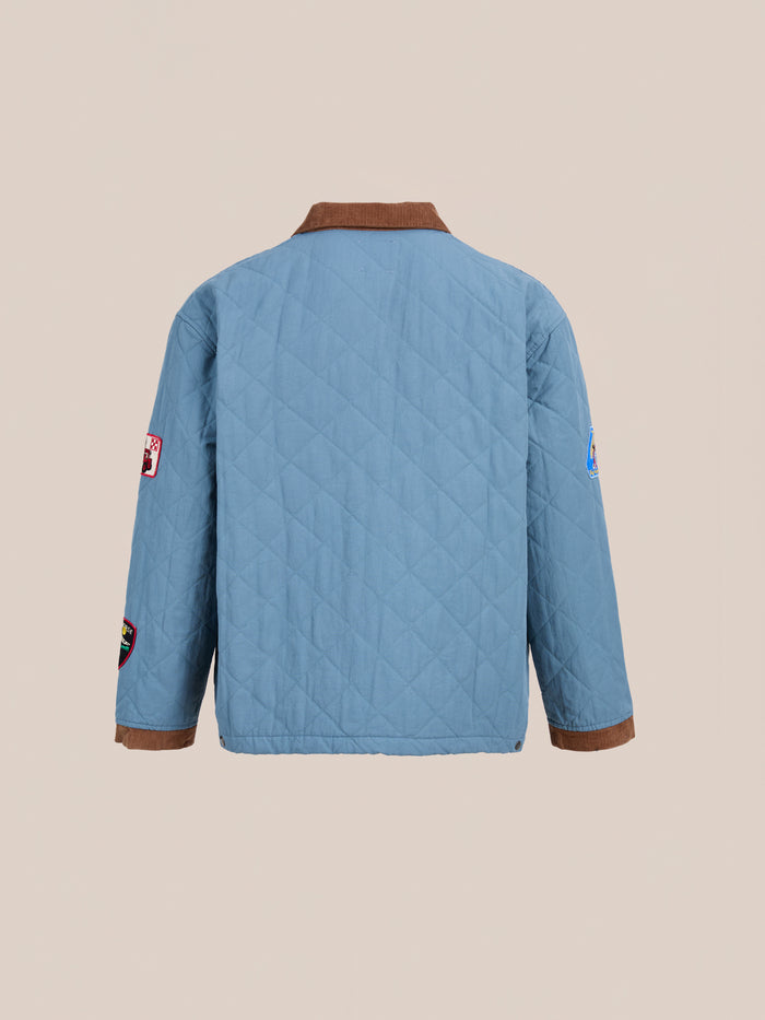A light blue FOUND Farmstead Quilt Patch Jacket with a brown collar and cuffs, plus sleeve patches, is displayed from the back against a plain background.
