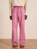 Person wearing FOUND Flare Work Pants in pink, a cream long-sleeve shirt, and brown suede shoes, standing on a wooden floor against a plain light background.