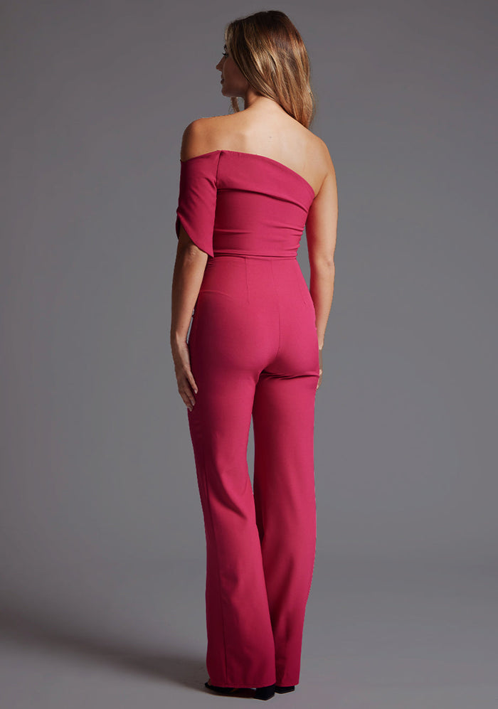 Side back image of a model wearing a  with a stunning one-shoulder design and a body-hugging fit that accentuates your curves in all the right places and side zip fastening ensures a seamless look. The design featured is the Vesper Ines One Shoulder Jumpsuit in Raspberry.