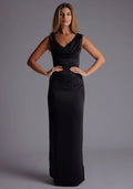 Front image of a model wearing the Vesper Jodie Cowl Neck Satin Maxi Dress in Black with a flowing cowl neckline and sleek maxi-length silhouette, standing against a grey studio backdrop.