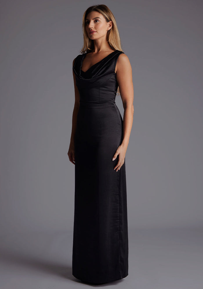 Side front image of a model wearing the Vesper Jodie Cowl Neck Satin Maxi Dress in Black highlighting the soft drape of the satin fabric and elongated silhouette.
