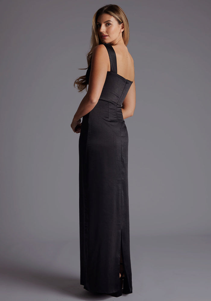 Side back image of a model wearing the Vesper Jodie Cowl Neck Satin Maxi Dress in Black featuring the smooth satin finish and subtle back skirt split.