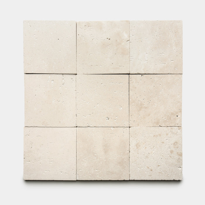 Nine Mesa 6x6 tiles by Zia Tile are arranged in a 3x3 grid on a white background. The beige tiles feature a natural, subtly textured surface with gentle variations and small pores.
