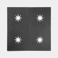 Four Nova Black 8x8 cement tiles by vendor-unknown are arranged in a grid, each showcasing a white eight-pointed star at the center—perfect for creating a striking kitchen backsplash.