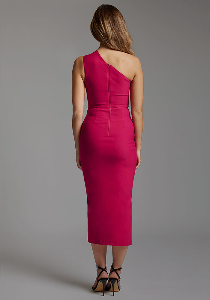 Back image of a model wearing a cerise midaxi dress with a asymmetric one-shoulder design features a tasteful cut out, while the front skirt split adds a chic, dynamic element and flattering bodycon fit. The design featured is the Vesper Ollie Cerise One Shoulder Midaxi Dress