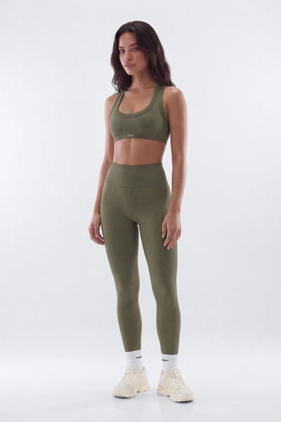 Woman wearing a green athletic outfit on a white background