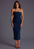 Front image of a model wearing a navy midaxi dress, featuring a strapless neckline with gold zip at the back. The design featured is the Vesper Shelbie Navy Strapless Midaxi Dress.