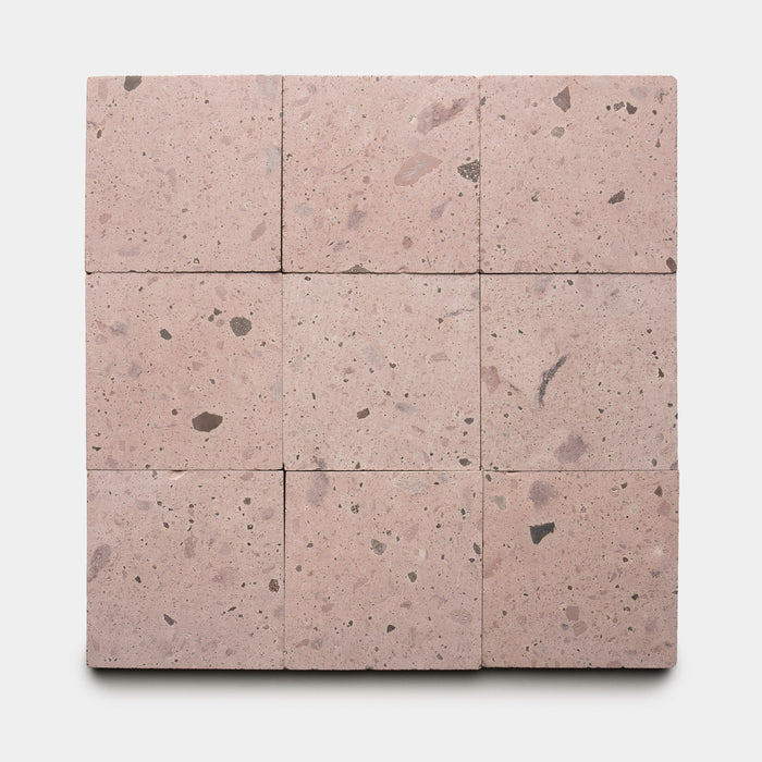 Nine Yuma 6x6 terrazzo tiles by Zia Tile, featuring light pink tones with small dark and light stone fragments, are arranged in a 3x3 grid on a white background.