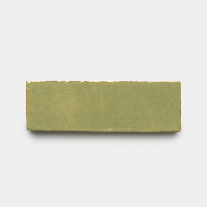 The Za'atar 2x6 by Zia Tile is a rectangular, glossy ceramic tile in muted olive green, shown on a plain white background.